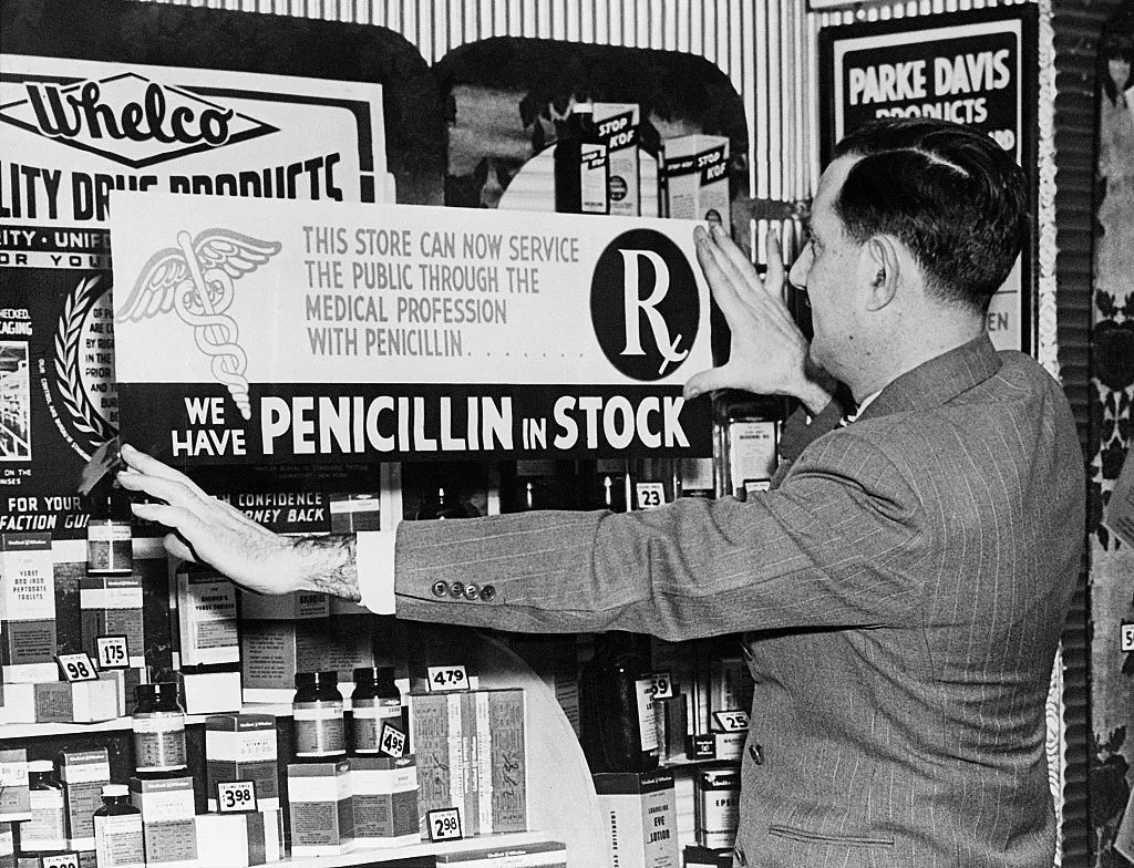 1945 New York: Manager Dave Tarlow of Whalen's Drug Store, 55 E. 42nd Street, is shown putting up a sign advertising the fact that they now have the wonder drug, penicillin, in stock. However, New Yorkers soon learned that the potent germ killer cannot be bought across the counter like liver pills but only by prescription and that it must be administered by a physician.